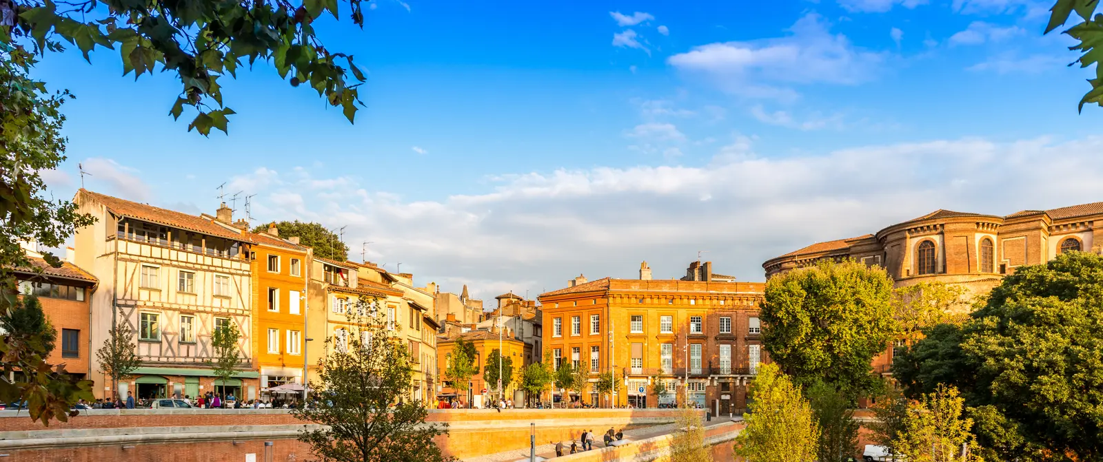 Deux visiteurs consultent un plan de ville sur une place de Toulouse.